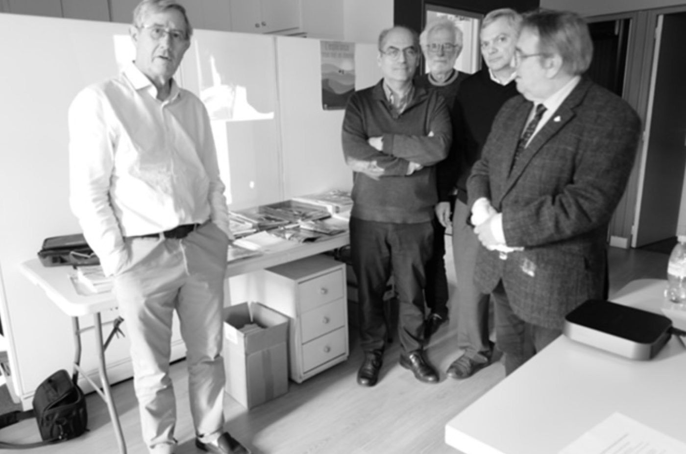 Cinq membres du projet debout dans une salle de réunion au siège de Pax Christi France